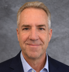 Professional headshot of smiling middle-aged man