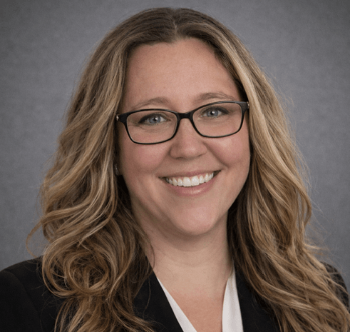 Smiling professional woman with glasses, wavy hair